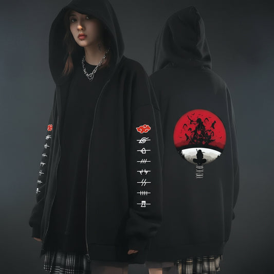 An oversized black hoodie with various anime character motifs on the sleeves and front, worn by a person in a natural pose.