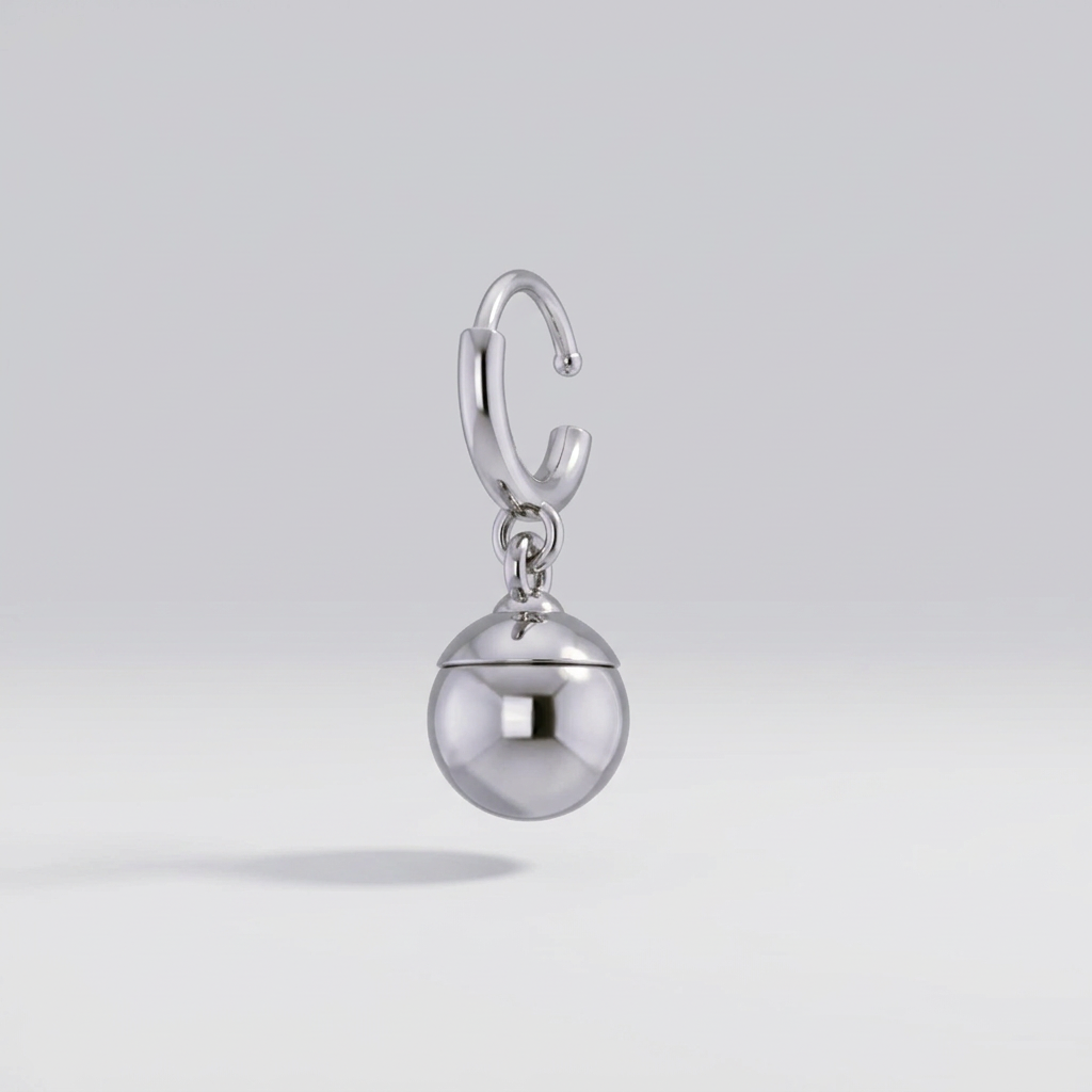 Silver earring with a spherical pendant on a light gray background