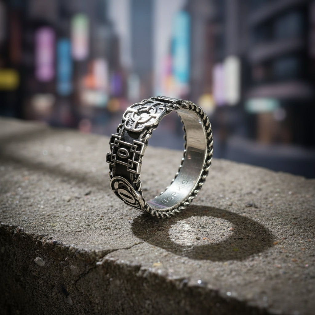 Silver ring with intricate design on a gray surface