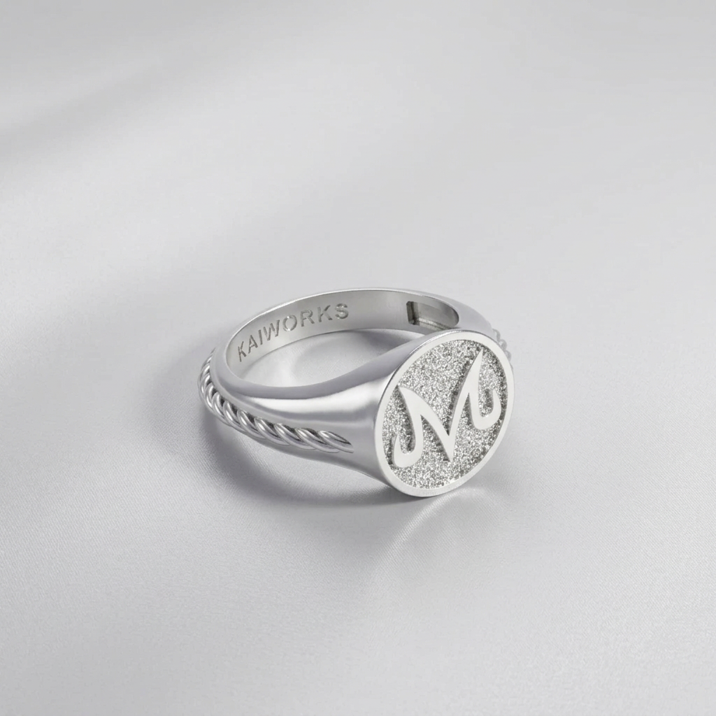 Silver ring with engraved design on a light gray background