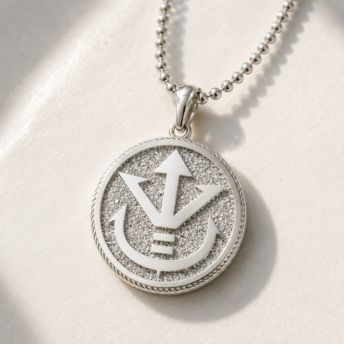 Silver pendant necklace with a detailed design on a light gray background