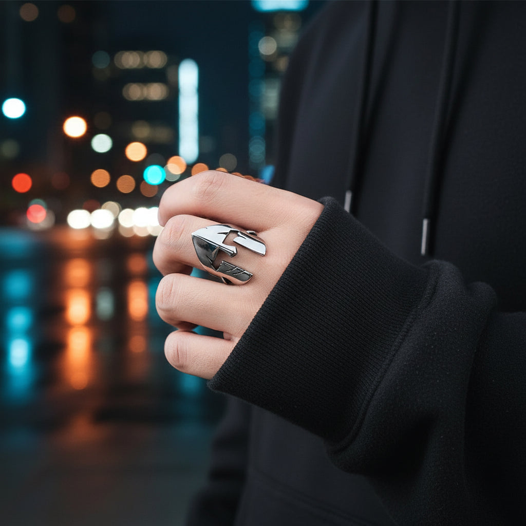 Silver ring with a unique design on a finger against a neutral background