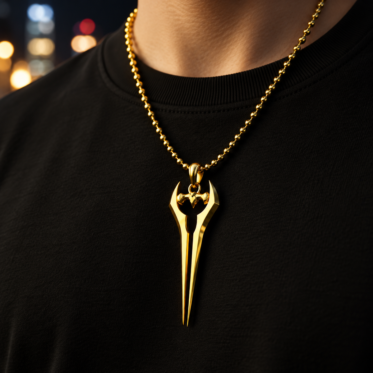 Gold necklace with a unique pendant on a black shirt against a blurred background