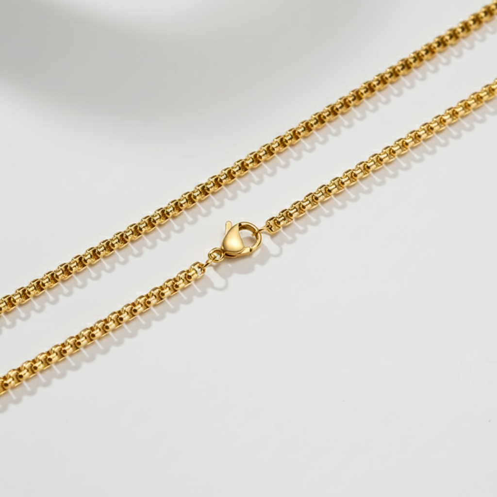 Gold chain necklace on a light gray background