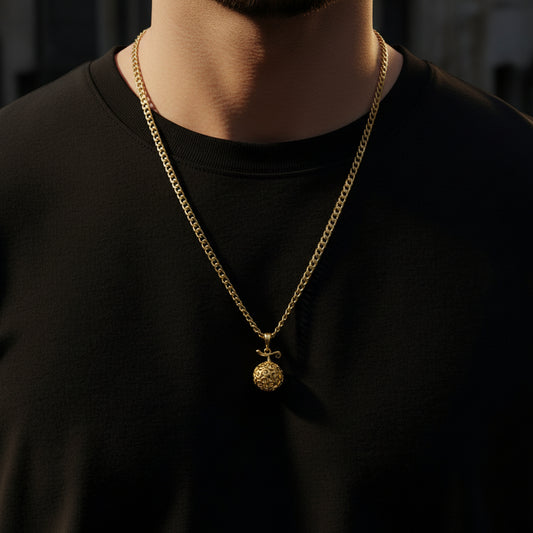 Gold chain necklace with a pendant on a gray background