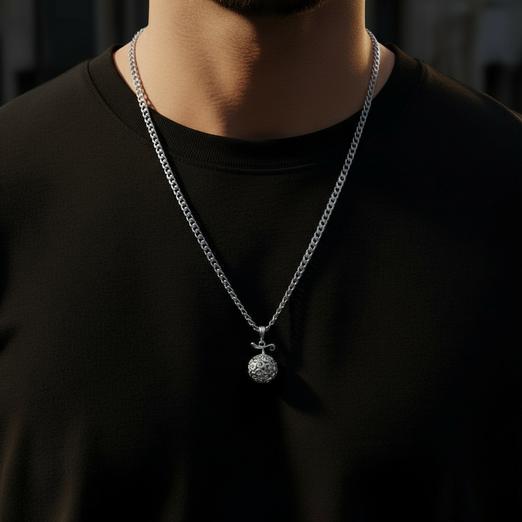 Gomu Gomu Pendant in 14K Gold worn on a silver chain, displayed elegantly against a dark shirt.