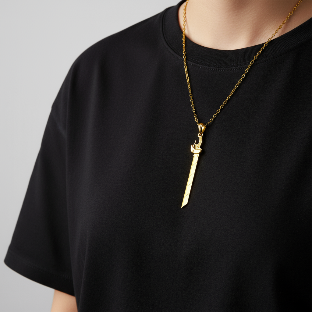Gold necklace with a unique pendant on a black shirt against a gray background