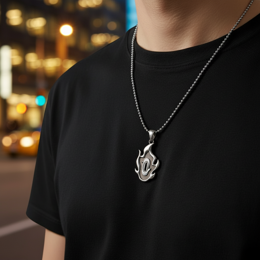 Person wearing a black t-shirt with a silver necklace featuring a flame pendant against a blurred cityscape background.