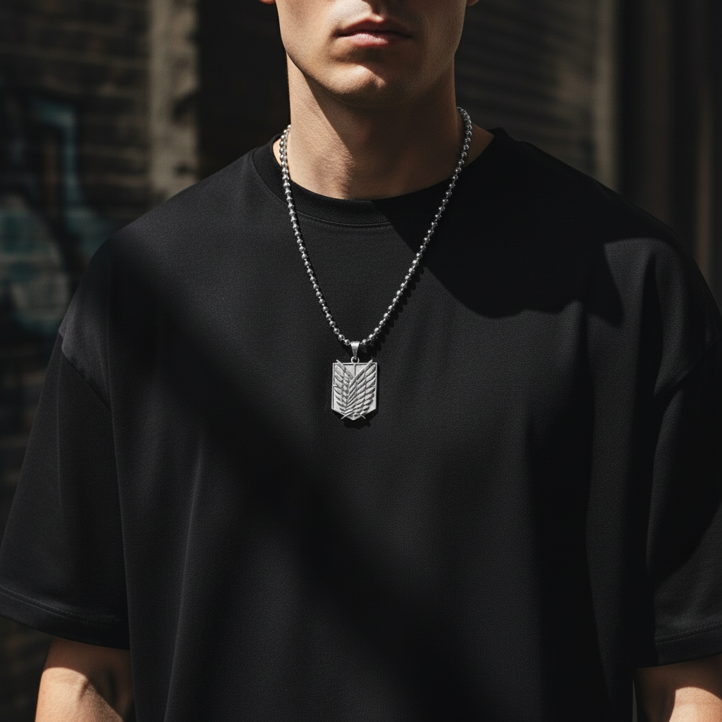 Person wearing a black shirt with a silver necklace featuring a pendant.