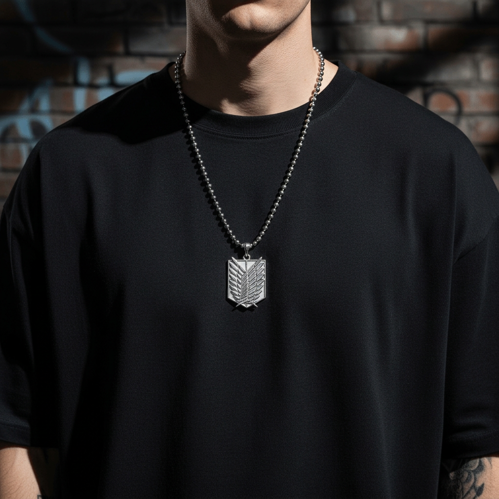 Person wearing a black t-shirt with a silver necklace featuring a pendant against a brick wall background