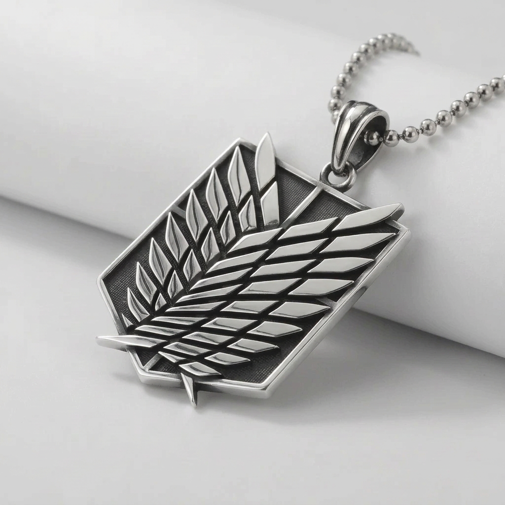 Silver pendant with a leaf design on a dark stone surface
