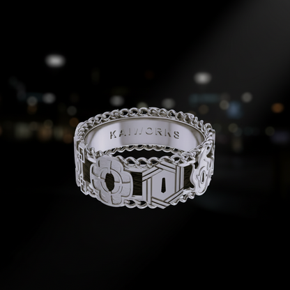 Silver ring with intricate design on a white background