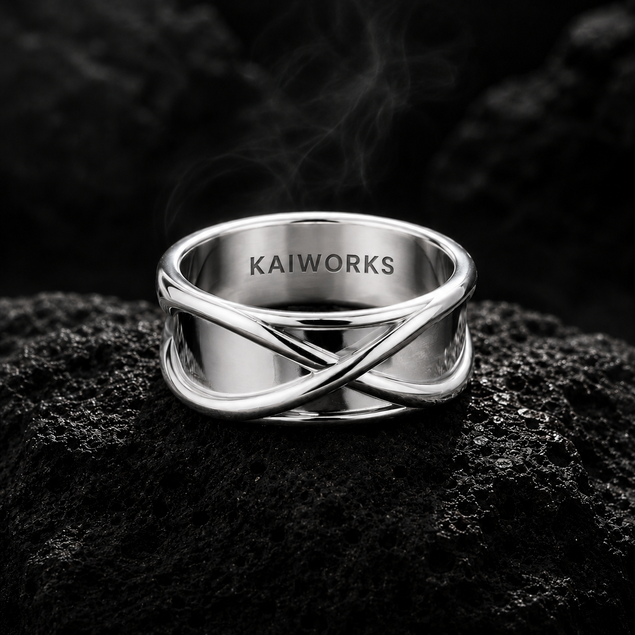 Silver ring with 'KAIWORKS' engraving on a dark textured surface