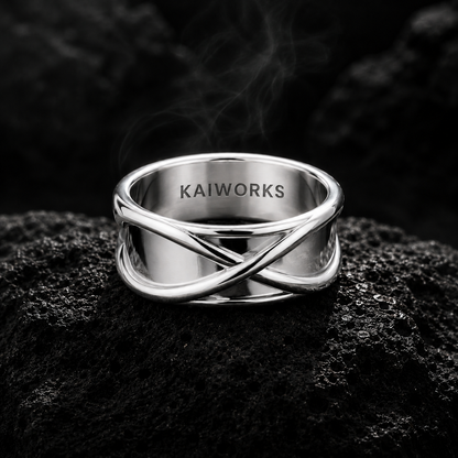 Silver ring with 'KAIWORKS' engraving on a dark textured surface