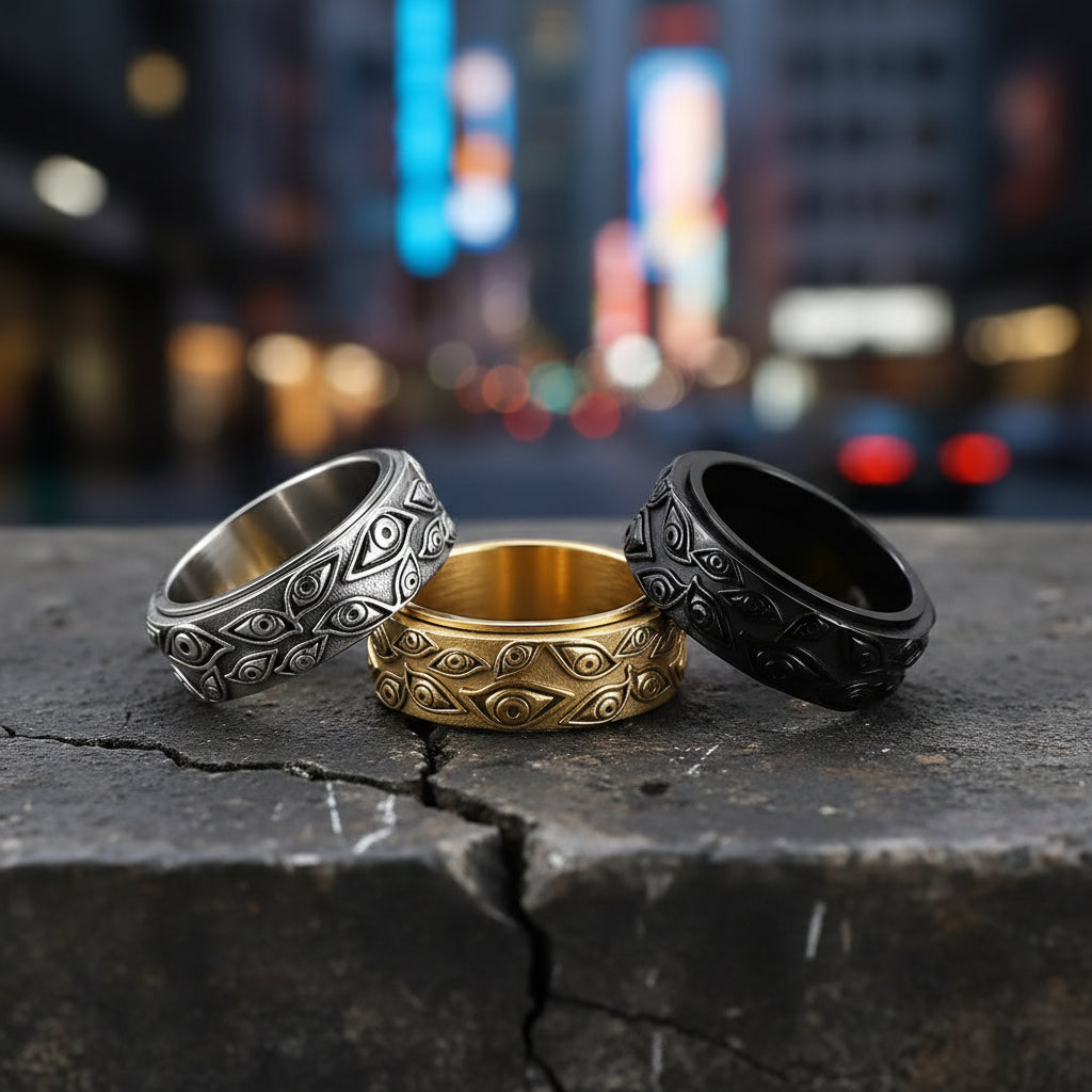 Three rings in silver, gold, and black on a light gray background