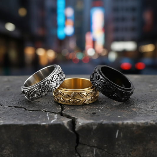 Three rings in silver, gold, and black on a light gray background