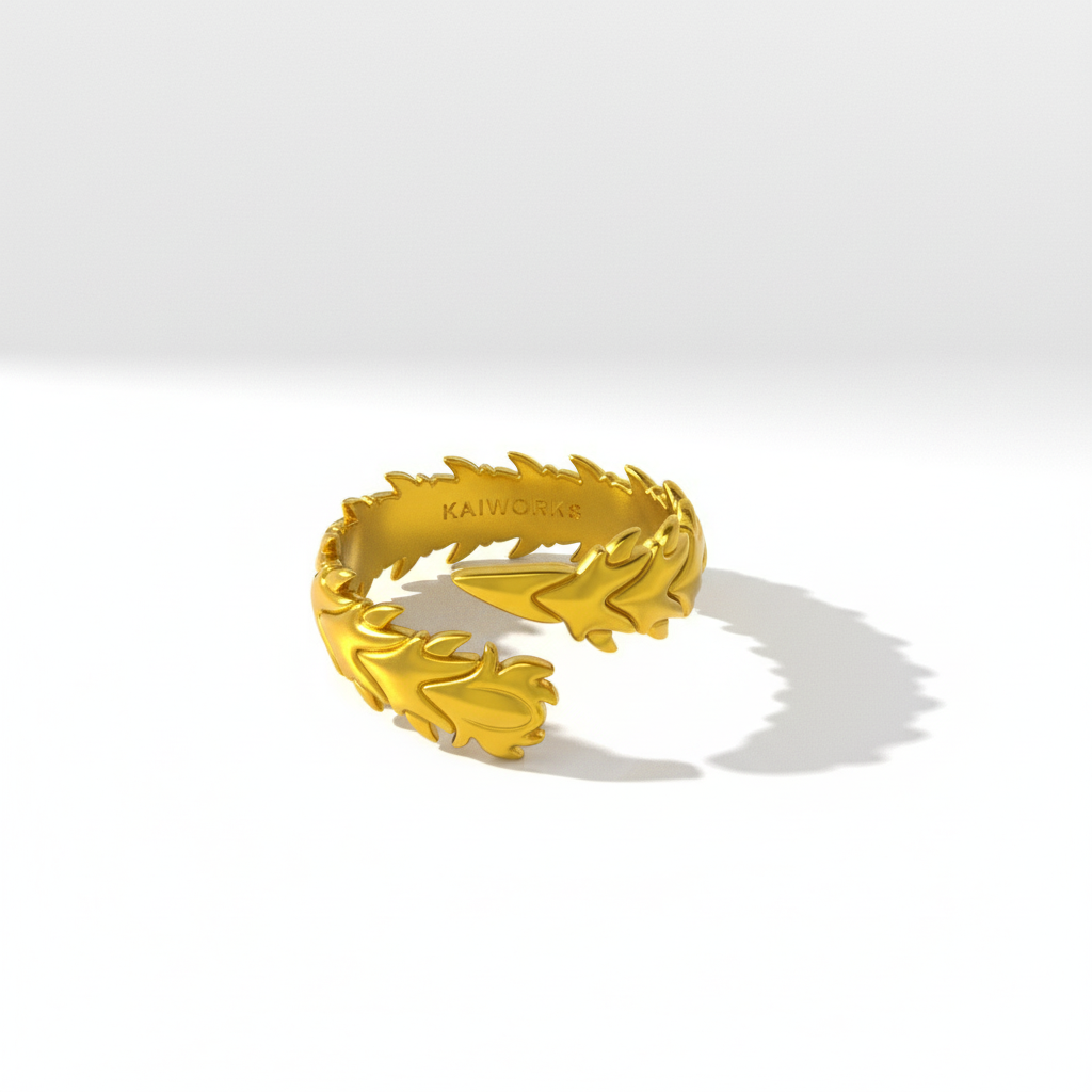 Gold ring with a leaf-like design on a white background