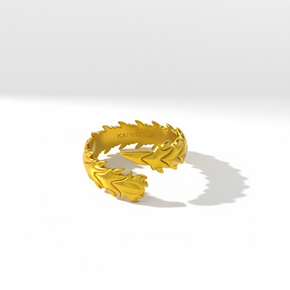 Gold ring with a leaf-like design on a white background