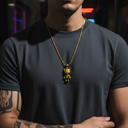 Person wearing a gold necklace with a pendant, standing against a dark background.