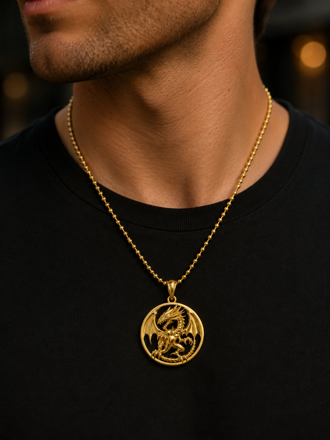 A close-up of a man wearing a gold chain necklace with a circular pendant featuring a detailed dragon design, styled with a black t-shirt.