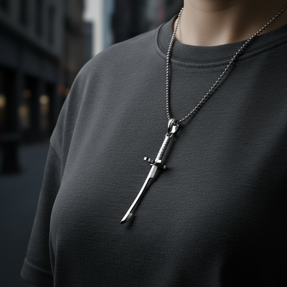 Person wearing a dark gray shirt with a unique necklace featuring a sword pendant.