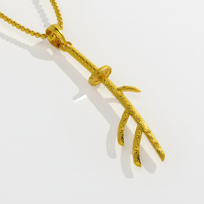 Gold branch-shaped pendant on a chain against a white background