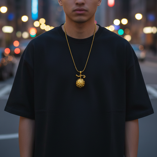 Person wearing a black t-shirt with a gold necklace in an urban setting
