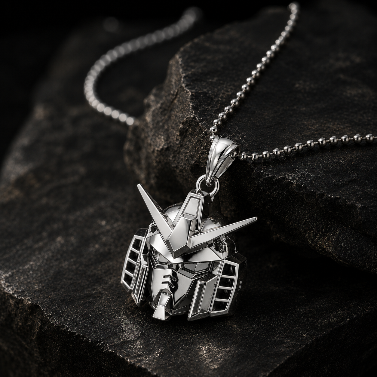 Silver robot head pendant on a chain against a dark stone background