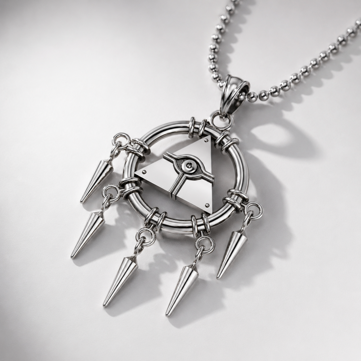 Silver necklace with geometric pendant and spikes on a light gray background