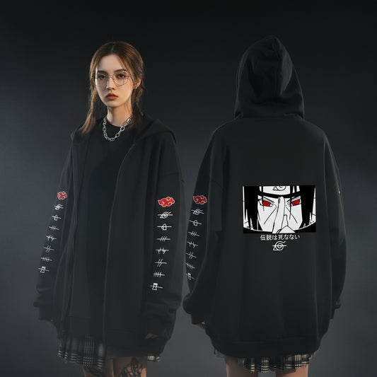 An oversized black hoodie with various anime character motifs on the sleeves and front, worn by a person in a natural pose.