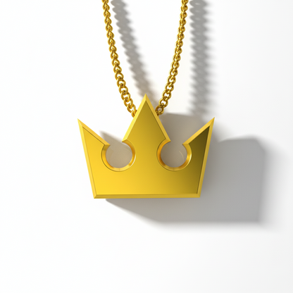 Gold crown-shaped pendant on a chain against a white background