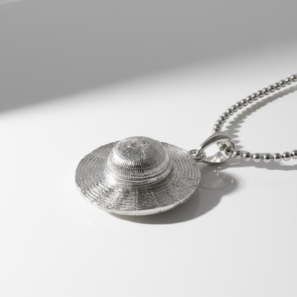 Silver hat-shaped pendant on a chain against a white background
